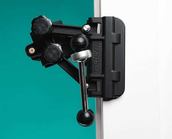 Front angle of massage gun holder clamped to door showing Monkee Mount logo